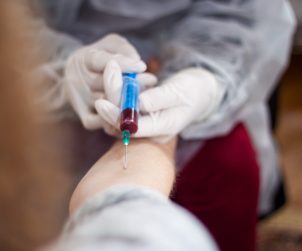 Doświadczony pielęgniarz pobiera pacjentowi krew z żyły u ręki. Źródło: 123rf.com