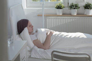 Samotna kobieta leży w łóżku szpitalnym. /Źródło: 123rf.com