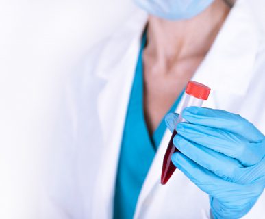 Lekarka w białym fartuchu trzyma w dłoni fiolkę z pobraną krwią pacjenta do analizy i dalszej diagnostyki. Źródło: 123rf.com