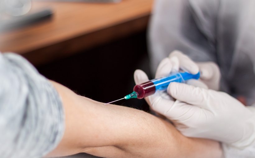 Pielęgniarz pobiera mężczyźnie krew z żyły u ręki, aby później przekazać próbkę do analizy laboratoryjnej. Źródło: 123rf.com