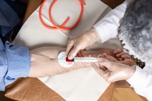 Pielęgniarz pobiera mężczyźnie krew z żyły u ręki w celu diagnostyki laboratoryjnej. 