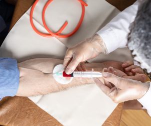 Pielęgniarz pobiera mężczyźnie krew z żyły u ręki w celu diagnostyki laboratoryjnej. Źródło: 123rf.com
