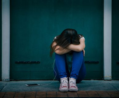Smutna nastolatka siedzi samotna na schodach na zewnątrz domu. /Źródło: 123rf.com
