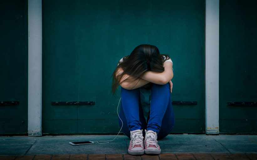 Smutna nastolatka siedzi samotna na schodach na zewnątrz domu. /Źródło: 123rf.com