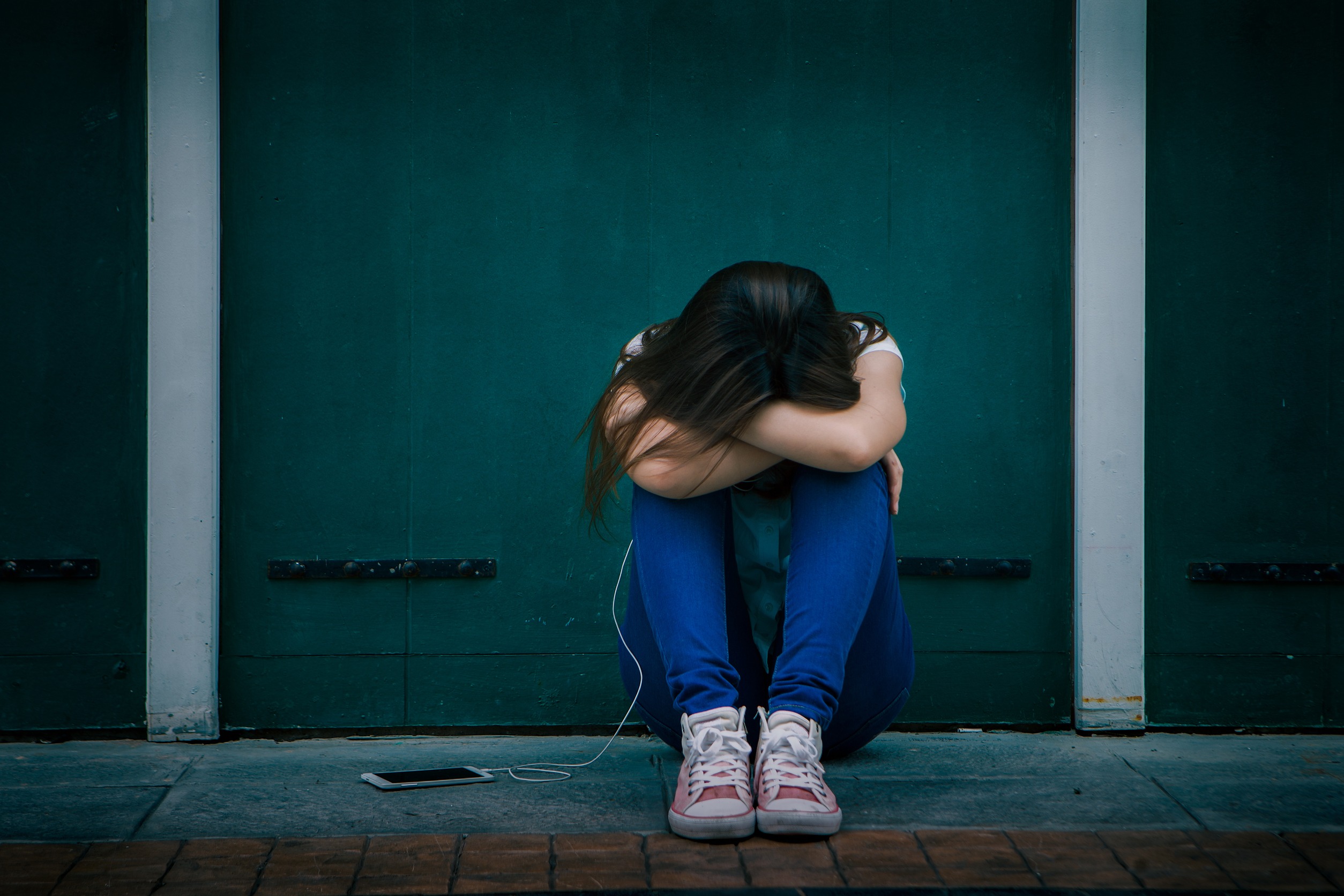 Smutna nastolatka siedzi samotna na schodach na zewnątrz domu. /Źródło: 123rf.com
