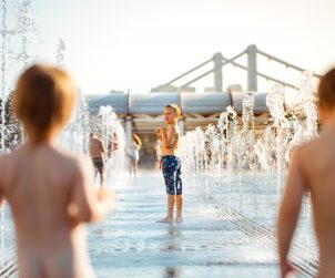 Dzieci bawią się w fontannie wodnej w czasie upału. /Źródło: 123rf.com