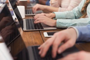 Grupa ludzi korzysta z laptopów w pracy. /Źródło: 123rf.com