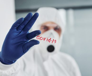 Lekarz odziany w sterylny strój przedstawia napis covid. /Źródło: 123rf.com