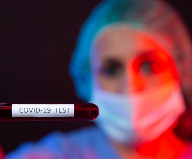 Pielęgniarka w sterylnym stroju trzyma w dłoniach fiolkę z próbką krwi. /Źródło: 123rf.com