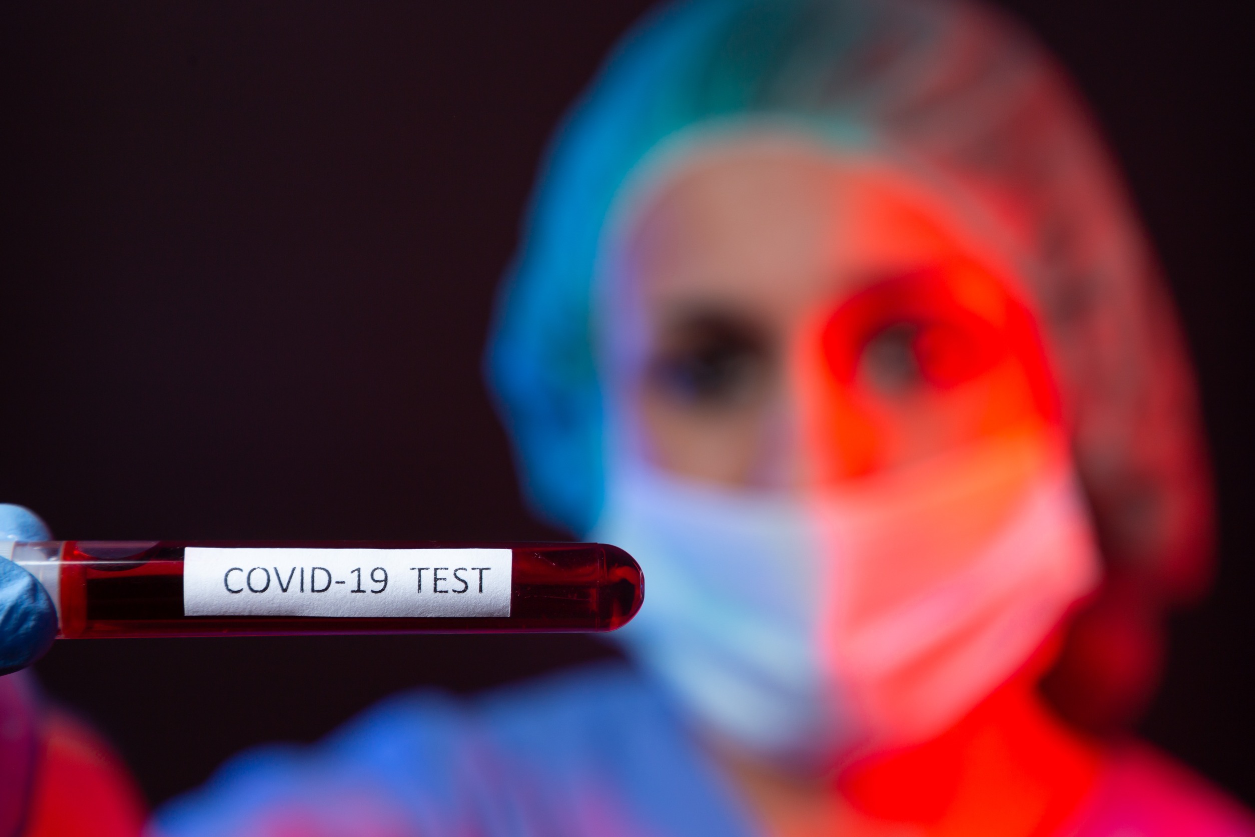 Pielęgniarka w sterylnym stroju trzyma w dłoniach fiolkę z próbką krwi. /Źródło: 123rf.com