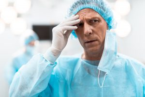 Chirurg trzyma się za czoło po ciężkim dyżurze. /Źródło: 123rf.com