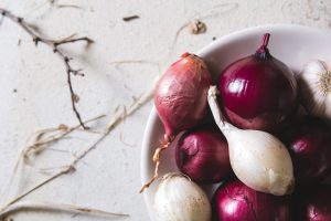 Biała oraz czerwona cebula na talerzu. /Źródło: 123rf.com