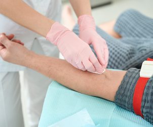 Process of taking blood from a patient for a further rejuvenating plasmolifting procedure, medical staff in protective gloves
