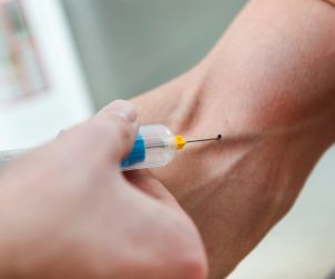 Portrait of medical technologist doing a blood draw services for patient.